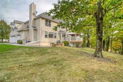 Rear view of house with a deck and a lawn | Image 3