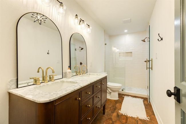 Fully updated primary en-suite boasts modern finishes, including a sleek dual vanity, stylish tilework, and a spacious walk-in shower. | Image 24