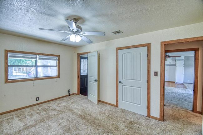 Unfurnished bedroom with carpet floors, a textured ceiling, a ceiling fan, and baseboards | Image 11