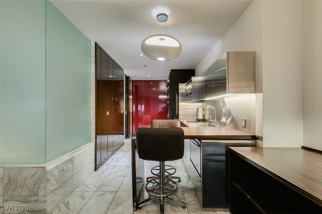 Kitchen with modern cabinets, light marble finish floors, and hanging light fixtures | Image 26