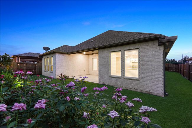 This private backyard retreat is beautiful by day or night, offering a peaceful setting with lush landscaping, a spacious covered patio and a grassy lawn with a full sprinkler system for easy care. | Image 38