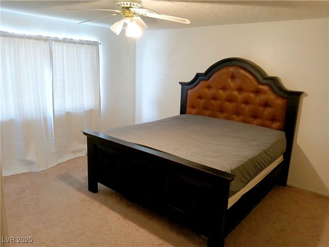 Carpeted bedroom with a ceiling fan | Image 6