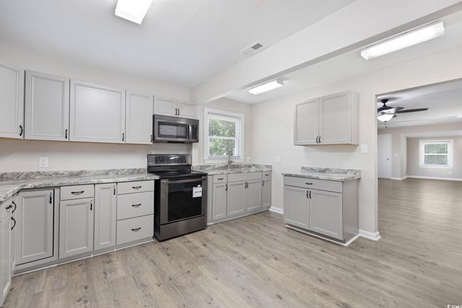 Kitchen featuring appliances with stainless steel finishes, light wood finished floors, healthy amount of natural light, and a sink | Image 18