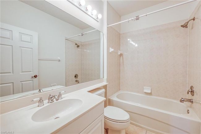 Full bathroom featuring tile patterned flooring, vanity, tiled shower / bath, and toilet | Image 6