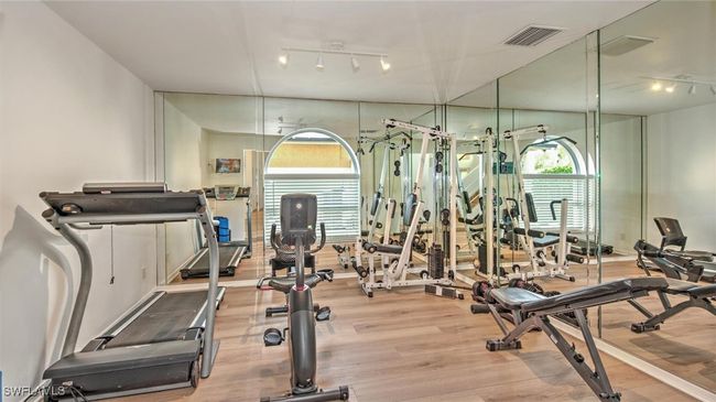Exercise room featuring rail lighting, wood finished floors, and healthy amount of natural light | Image 29