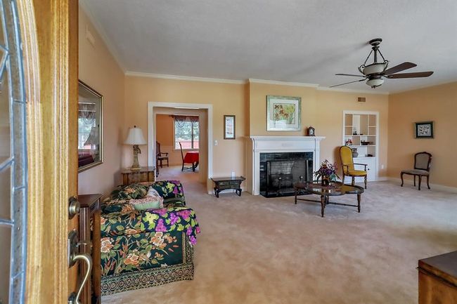 Entering through the front glassed in porch, you're welcomed into this spacious formal living room with built ins and a fireplace. | Image 7