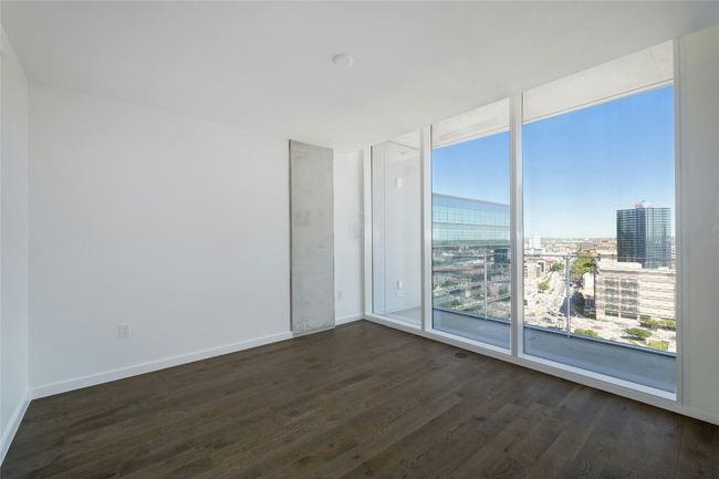 Bedroom room with a city view, wood-style floors, baseboards, and expansive windows | Image 21
