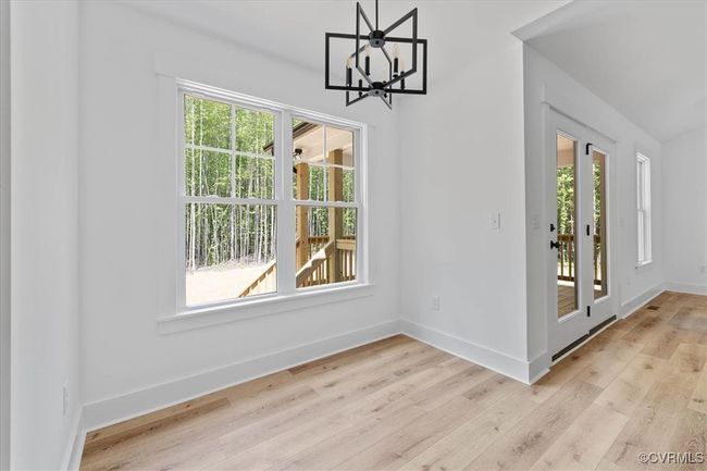 Unfurnished dining area with baseboards, a chandelier, and light wood-style flooring | Image 15