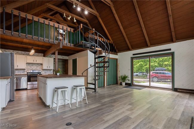 Kitchen featuring stainless steel appliances, wood counters, white cabinets, wooden ceiling with exposed beams, and light wood finished floors | Image 8