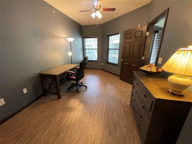 Office area with wood finished floors, a ceiling fan, and baseboards | Image 14
