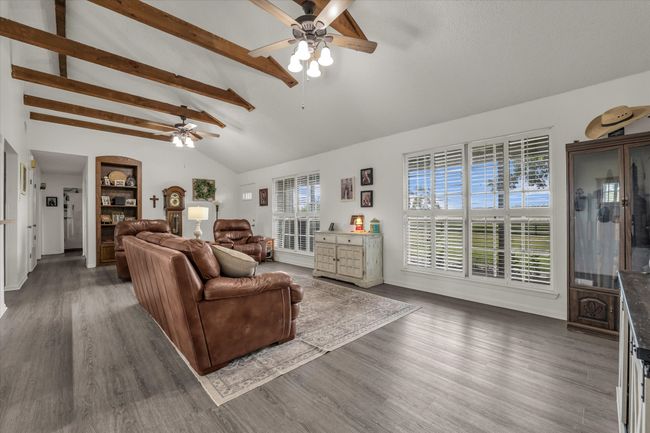 Living area featuring ceiling fan and dark wood finished floors | Image 24