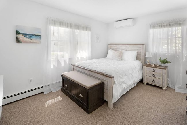 Carpeted bedroom with a baseboard radiator and a wall mounted AC | Image 18