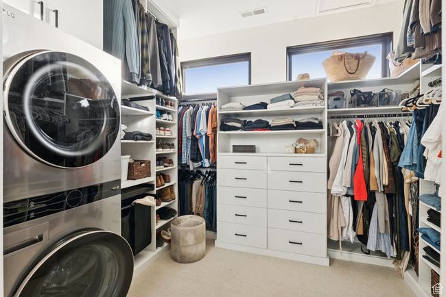 Laundry area featuring estacked washer and dryer and carpet floors | Image 41
