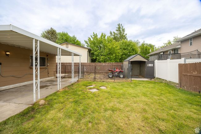 View of yard with a storage unit and an outdoor structure | Image 29