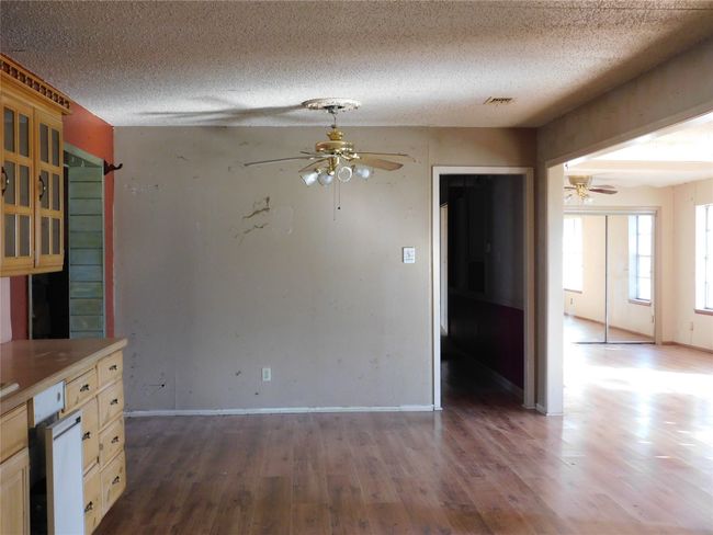 Unfurnished dining area featuring ceiling fan, a textured ceiling, and hardwood / wood-style flooring | Image 7