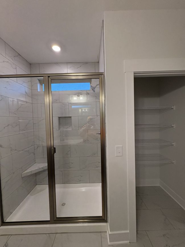 STOCK PHOTO. SELECTIONS WILL VARY IN ACTUAL HOUSE. Primary bathroom with tiled shower and linen closet. | Image 18