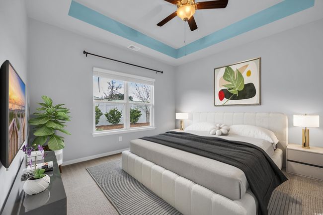 Bedroom featuring visible vents, baseboards, a tray ceiling, wood finished floors, and a ceiling fan | Image 8