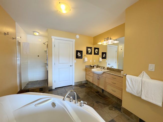 Full bathroom with a tub, a shower stall, vanity, and stone finish flooring | Image 23
