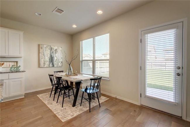 Dining room with healthy amount of natural light, light wood finished floors, and recessed lighting | Image 15