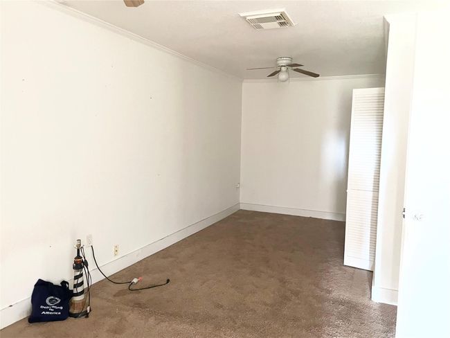 Empty room with a ceiling fan and crown molding | Image 5