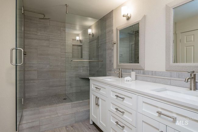 Bathroom with a stall shower, double vanity, and wood finished floors | Image 9