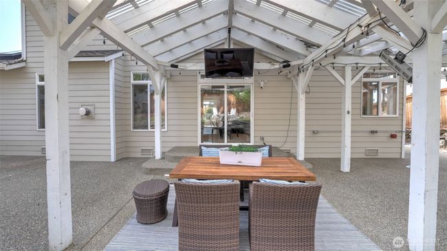 A large covered area welcomes you as you step outside, complete with a table and a cozy relaxation spot. Decorative lights enhance the ambiance, and there’s plenty of space to add a screen, TV, or projector for extra entertainment! | Image 32