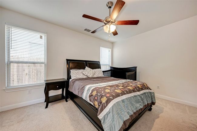 Bedroom with light carpet, baseboards, and ceiling fan | Image 7