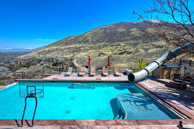 View of pool featuring a mountain view, fence, a water slide, and a fenced in pool | Image 62