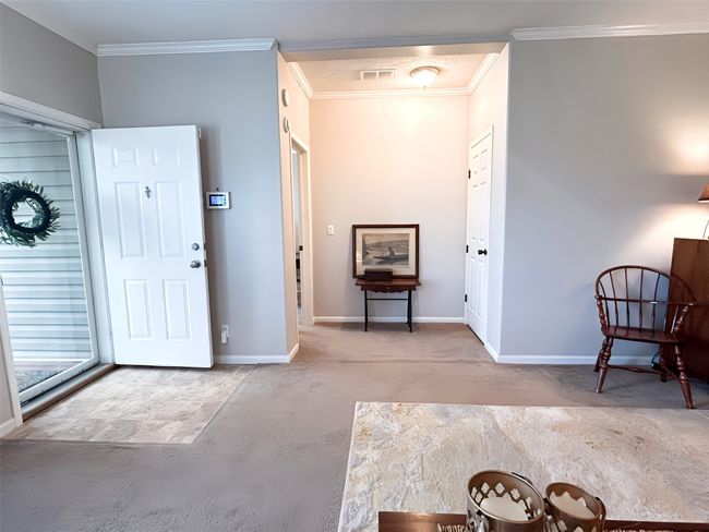 Carpeted entrance foyer with baseboards, ornamental molding, and visible vents | Image 10