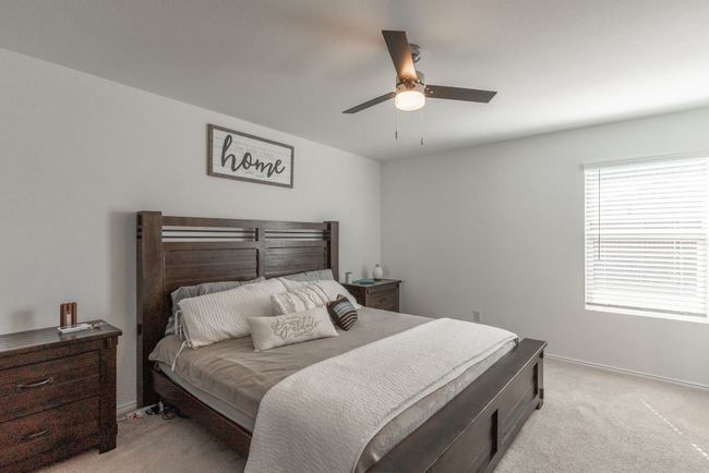 Bedroom with baseboards, a ceiling fan, and light carpet | Image 6