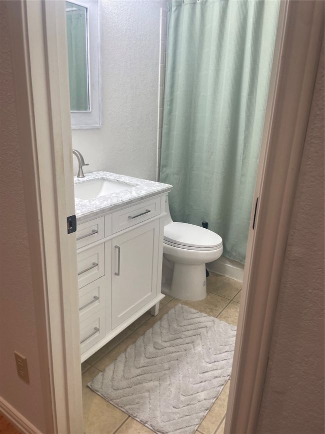 Full bath featuring tile patterned flooring, a textured wall, vanity, and a shower with curtain | Image 16