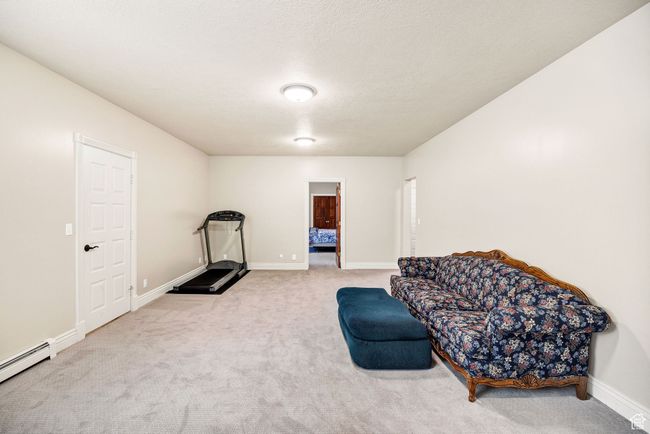 Sitting room featuring a baseboard radiator and carpet flooring | Image 65