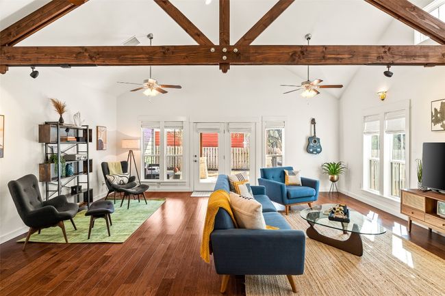 Living room featuring ceiling fan, wood finished floors, beamed ceiling, and high vaulted ceiling | Image 6