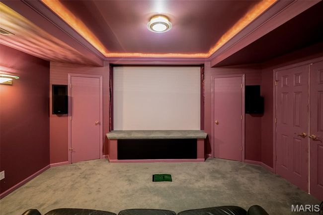 Carpeted cinema with a tray ceiling and baseboards | Image 45