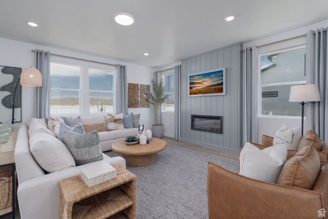 Living area with healthy amount of natural light, wood finished floors, a fireplace, and recessed lighting | Image 24