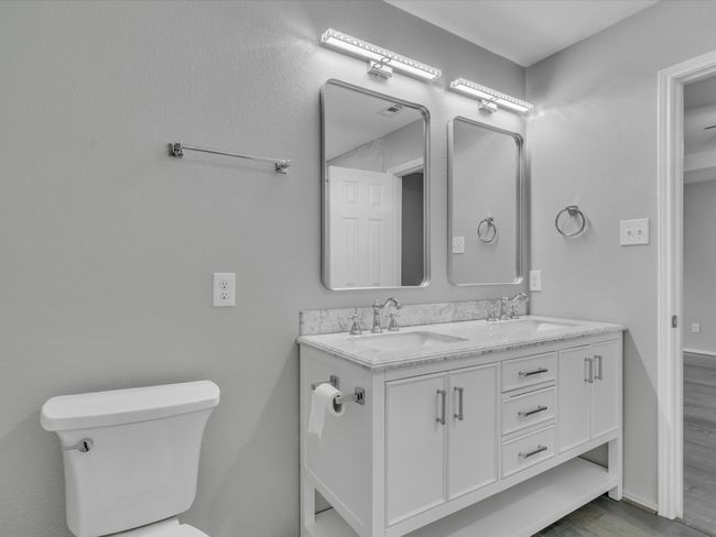 Bathroom with toilet, double vanity, and wood finished floors | Image 21