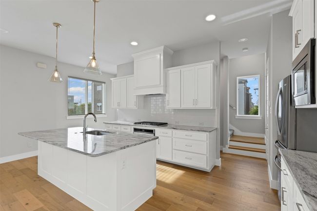 Kitchen featuring a sink, stainless steel microwave, healthy amount of natural light, white cabinetry, and recessed lighting | Image 7