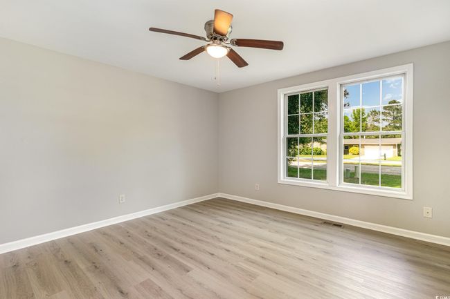Unfurnished room featuring light wood-type flooring, visible vents, ceiling fan, and baseboards | Image 12