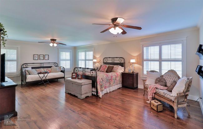 Bedroom with ornamental molding, wood floors, and a ceiling fan | Image 24