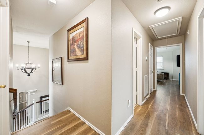 Upstairs corridor featuring attic access, an upstairs landing, and wood finished floors | Image 24