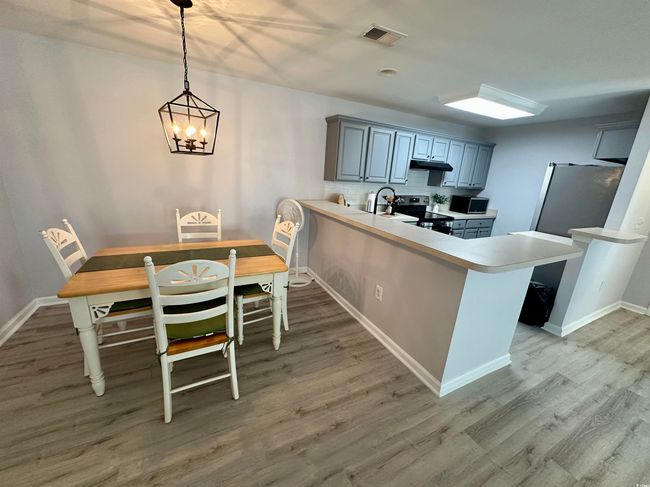 Empty room with light wood-style floors, ceiling fan, baseboards, and vaulted ceiling | Image 7