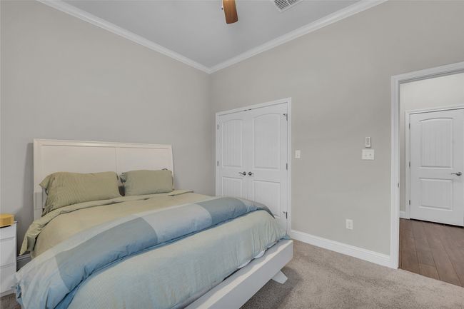 Bedroom with ornamental molding, baseboards, a ceiling fan, carpet flooring, and a closet | Image 30