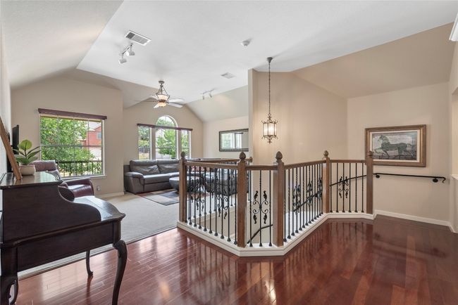 Light-filled upstairs living space with vaulted ceiling and iron baluster staircase. Electronic shades operated by remote control. | Image 20