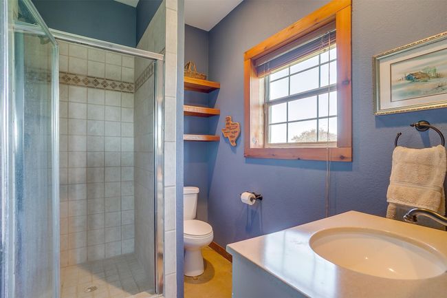 Bathroom featuring a sink, a shower stall, and toilet | Image 31