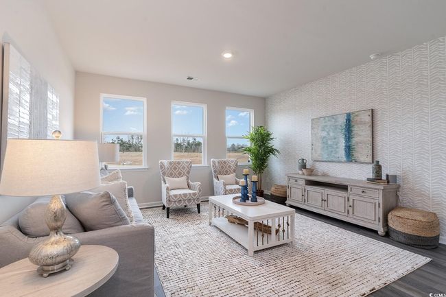 Living area with wood finished floors and wallpapered walls | Image 12