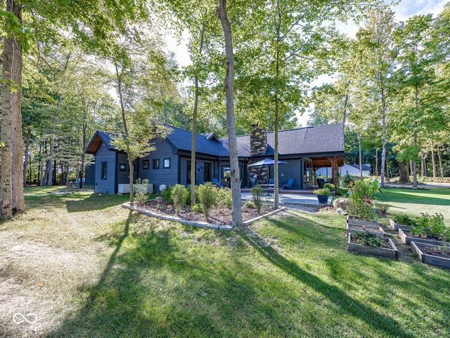back of house with a garden, a lawn, a chimney, and a shingled roof | Image 52