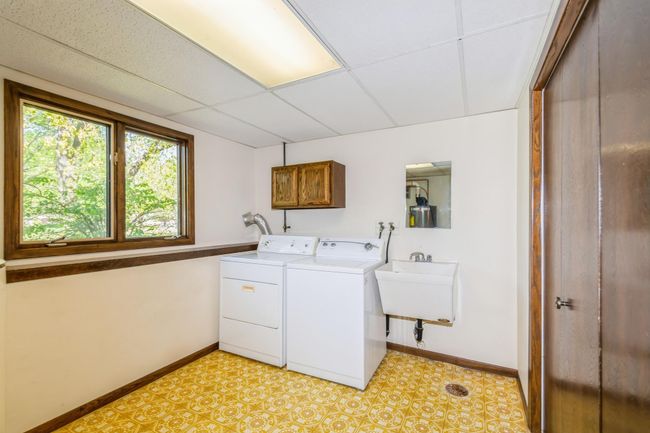 Lower level laundry and utility room is finished, has a closet for extra storage and a utility sink! | Image 46