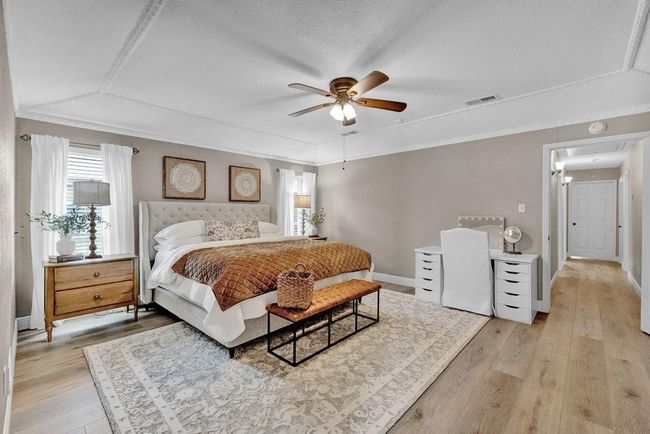 Bedroom featuring baseboards, attic access, light wood finished floors, and visible vents | Image 27
