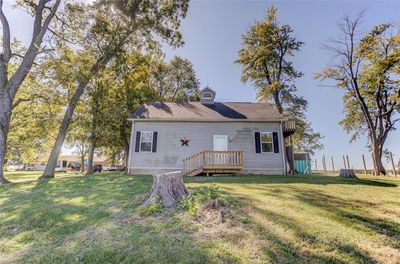 Front view of house with a deck and a lawn | Image 1