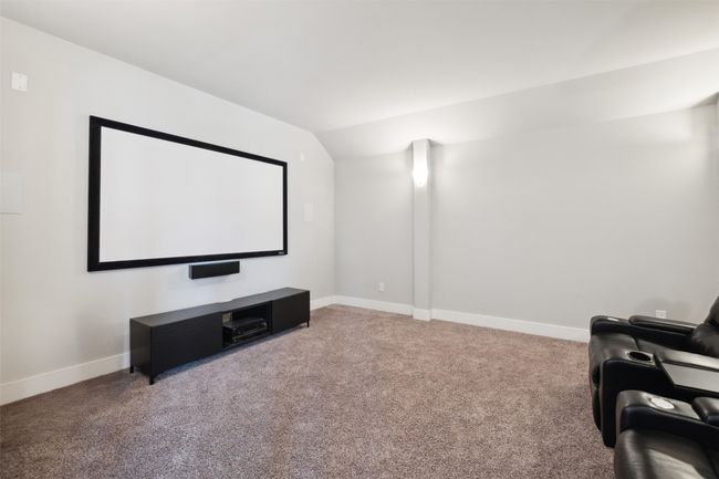 Carpeted home theater with baseboards and lofted ceiling | Image 31